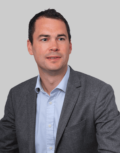 Professional businessman in a grey suit and light blue shirt, representing Gresham House’s investment and asset management expertise.