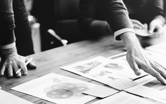 Hands of a man pointing at the papers, black and white photo