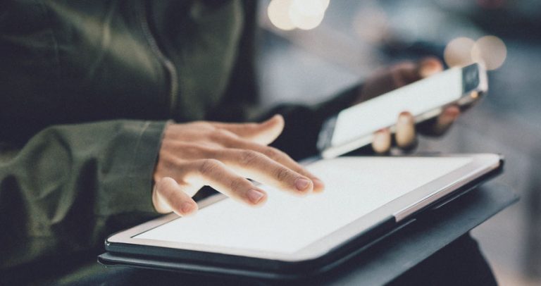 hand holding tablet and mobile phone