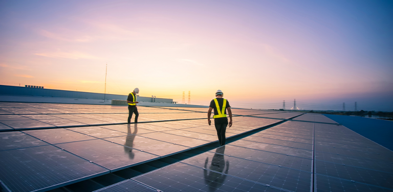 Men walk between solar panels