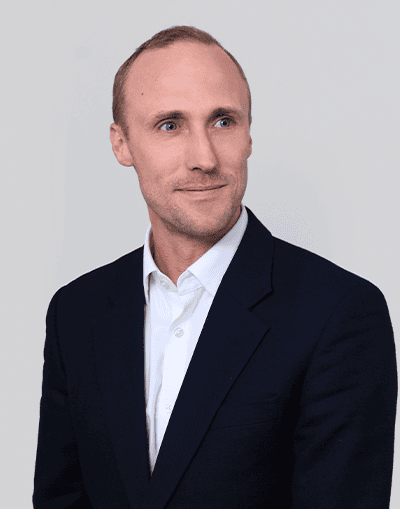 A professional businessman in formal attire looking thoughtfully to the side, representing Gresham House's expertise in investment management and sustainable financial solutions.