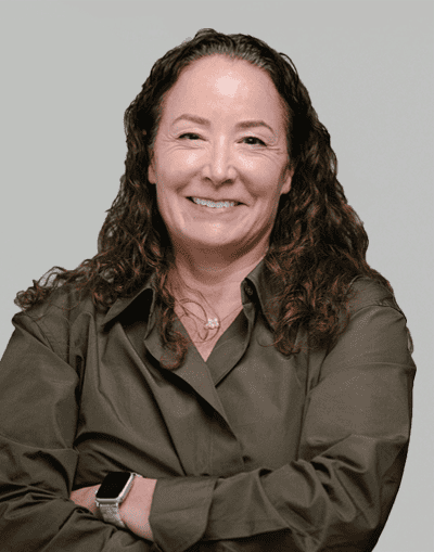 Experienced woman with curly hair smiling confidently, representing Gresham House's professional investment team in the UK.