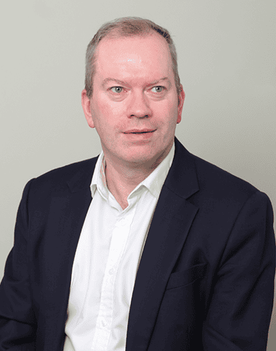 Experienced executive portrait of a professional man in formal business attire, suitable for corporate branding and investment firm profiles.