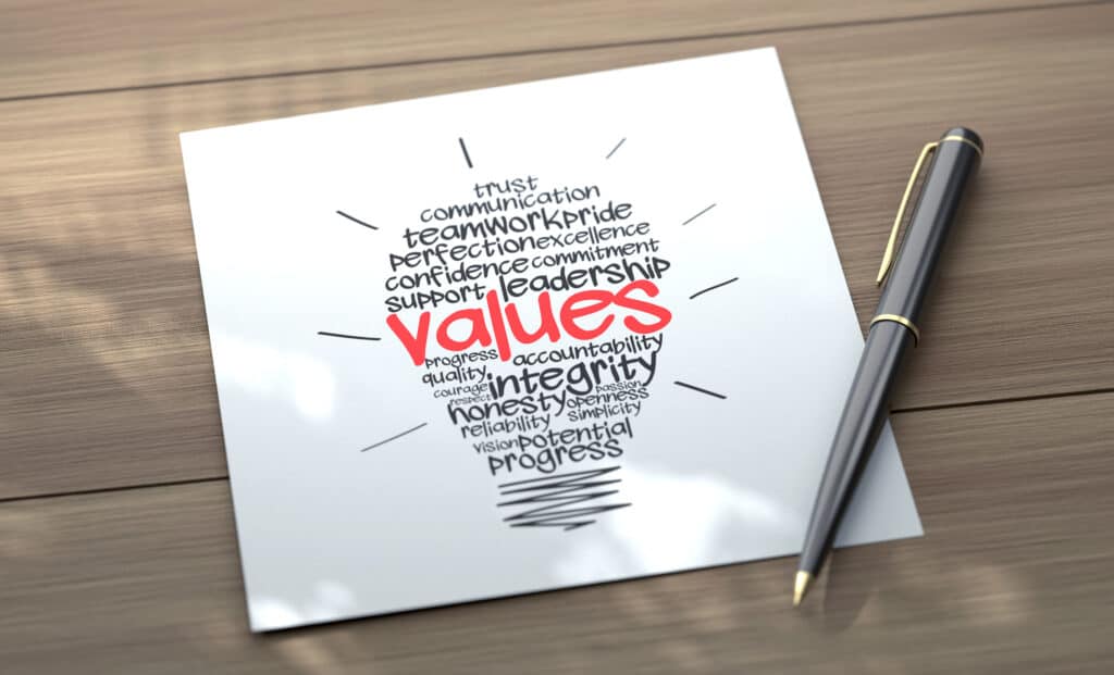 Valuable company values illustration on paper with a pen, emphasizing teamwork, integrity, honesty, leadership, and progress for business success.